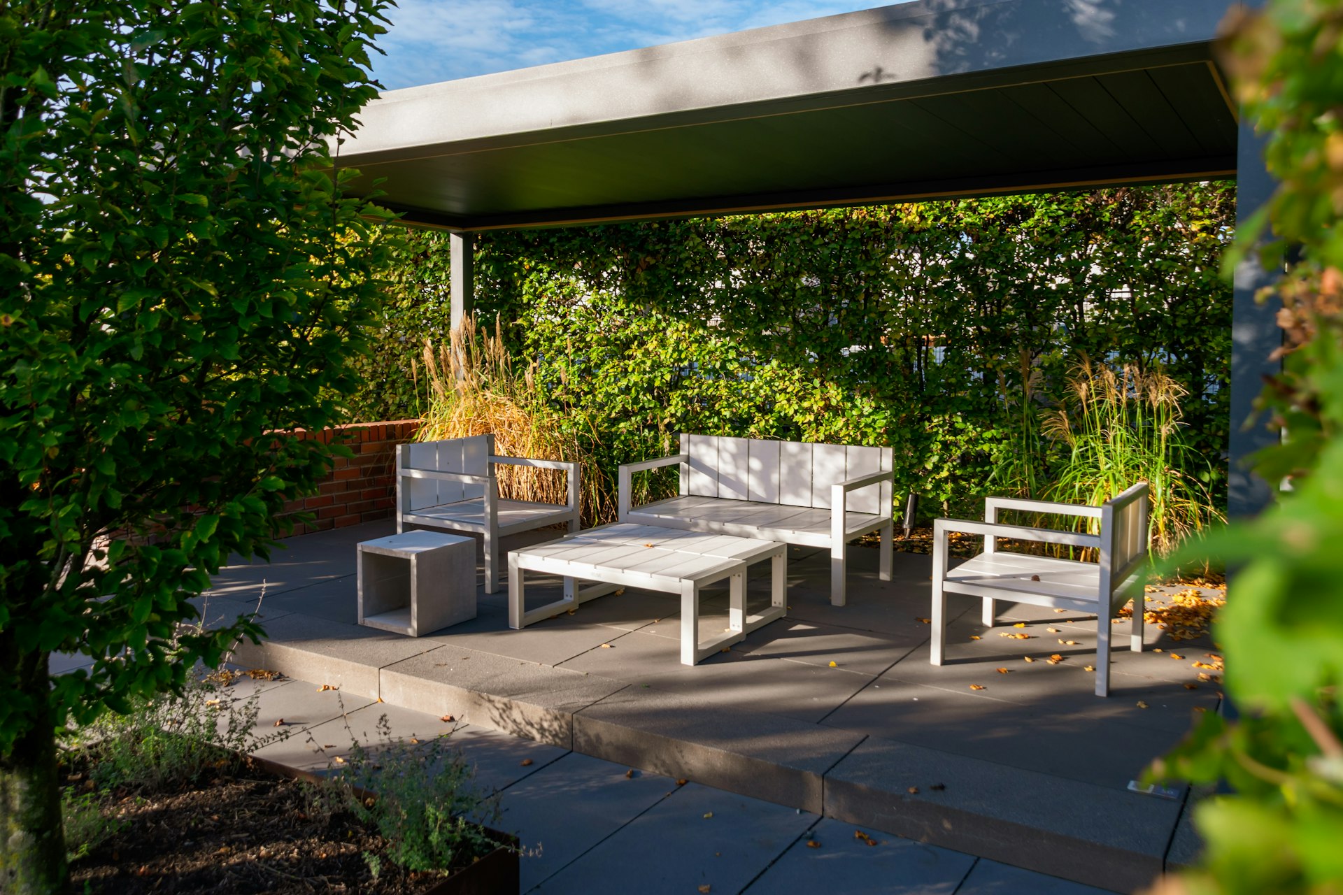 Modern outdoor seating area with white furniture.